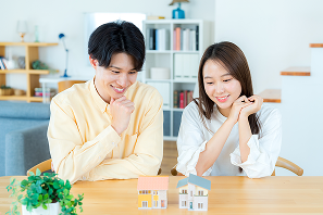 家の模型を見ながら相談する夫婦